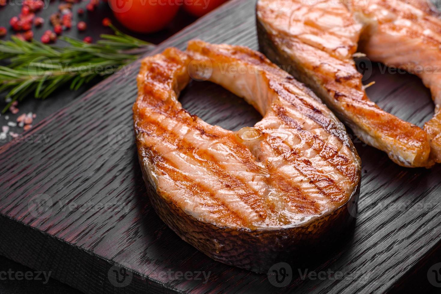 délicieux steak de saumon frais cuit avec des épices et des herbes cuites sur un gril photo