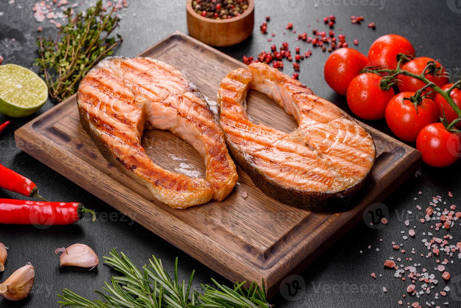 délicieux steak de saumon frais cuit avec des épices et des herbes cuites sur un gril photo