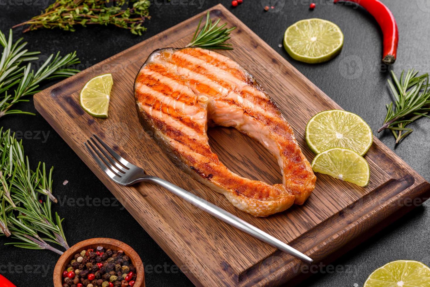délicieux steak de saumon frais cuit avec des épices et des herbes cuites sur un gril photo