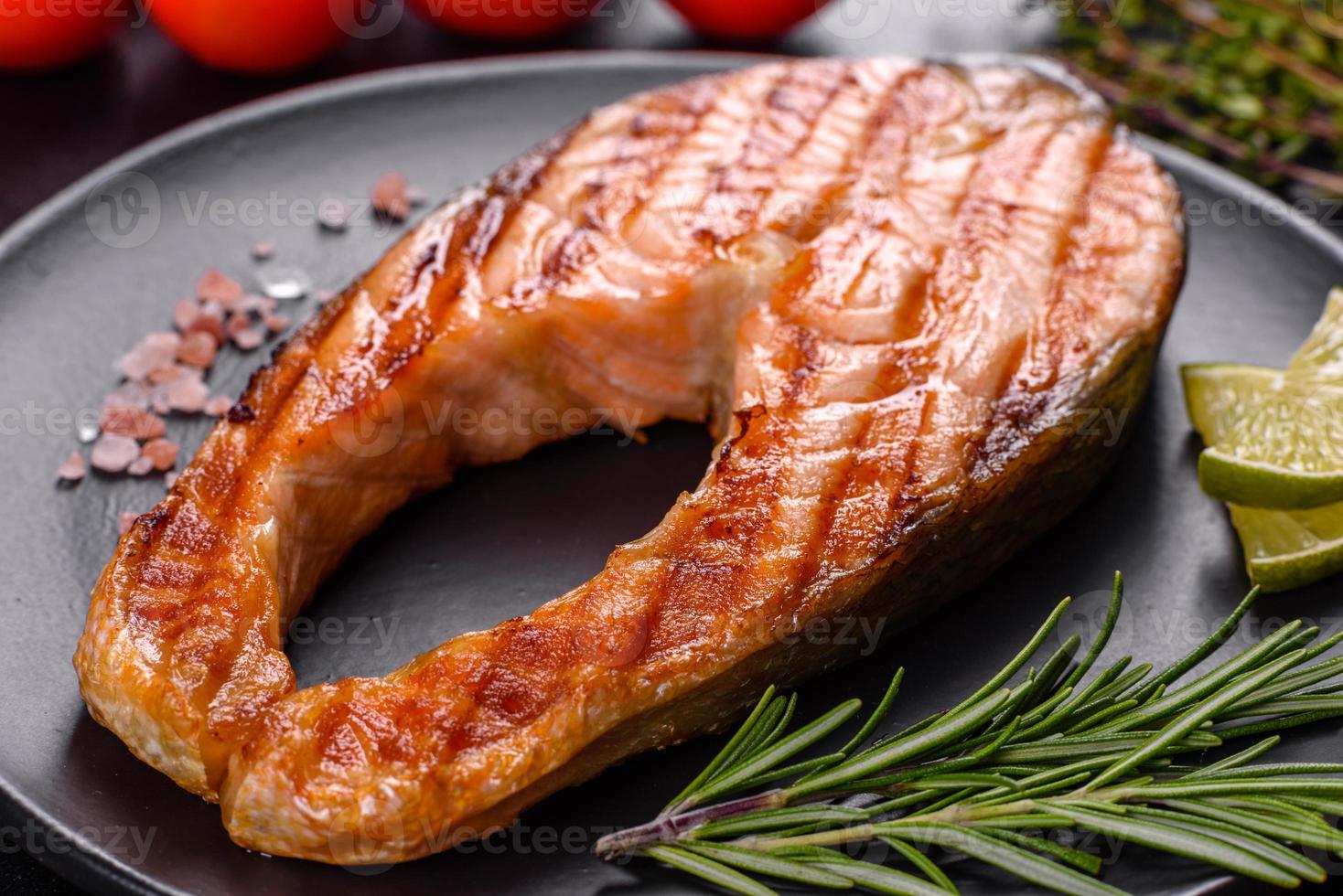 délicieux steak de saumon frais cuit avec des épices et des herbes cuites sur un gril photo