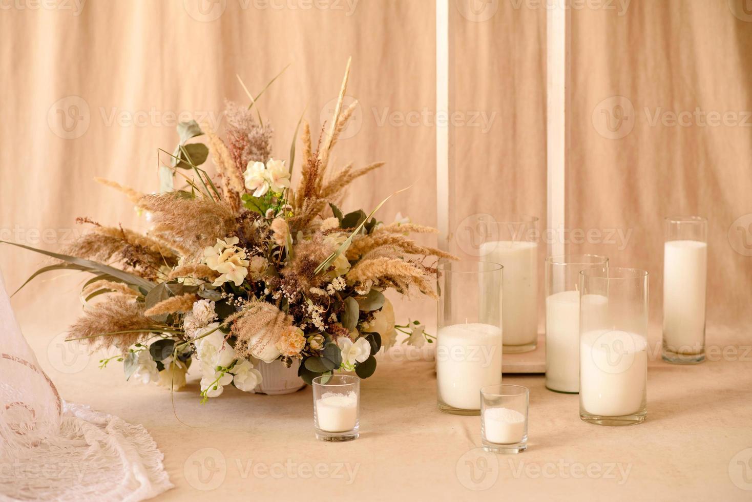 décorations de belles fleurs sèches dans un vase blanc sur fond de tissu beige photo