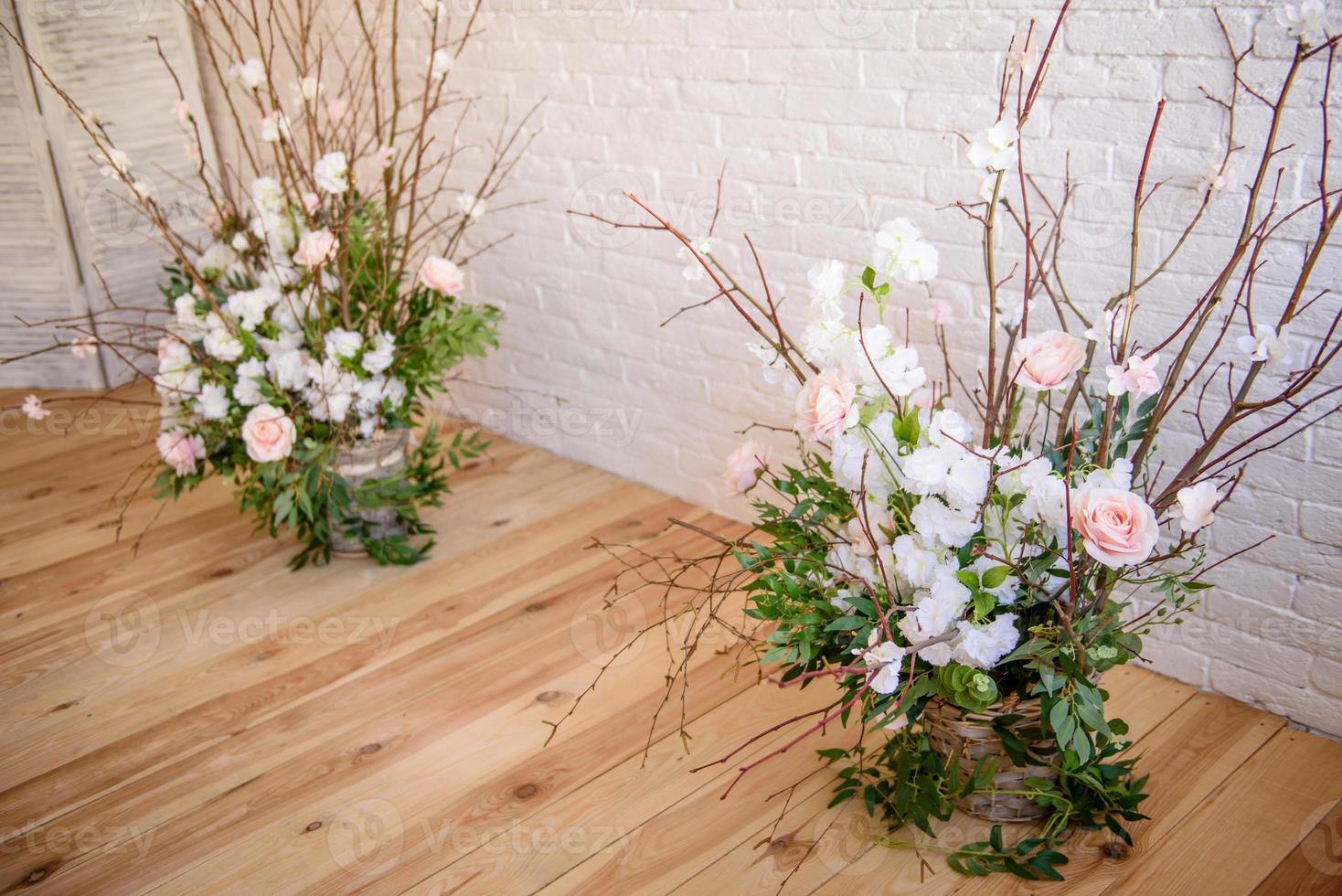 décorations de branches avec de belles fleurs roses et blanches dans le panier sur fond de mur de briques blanches photo