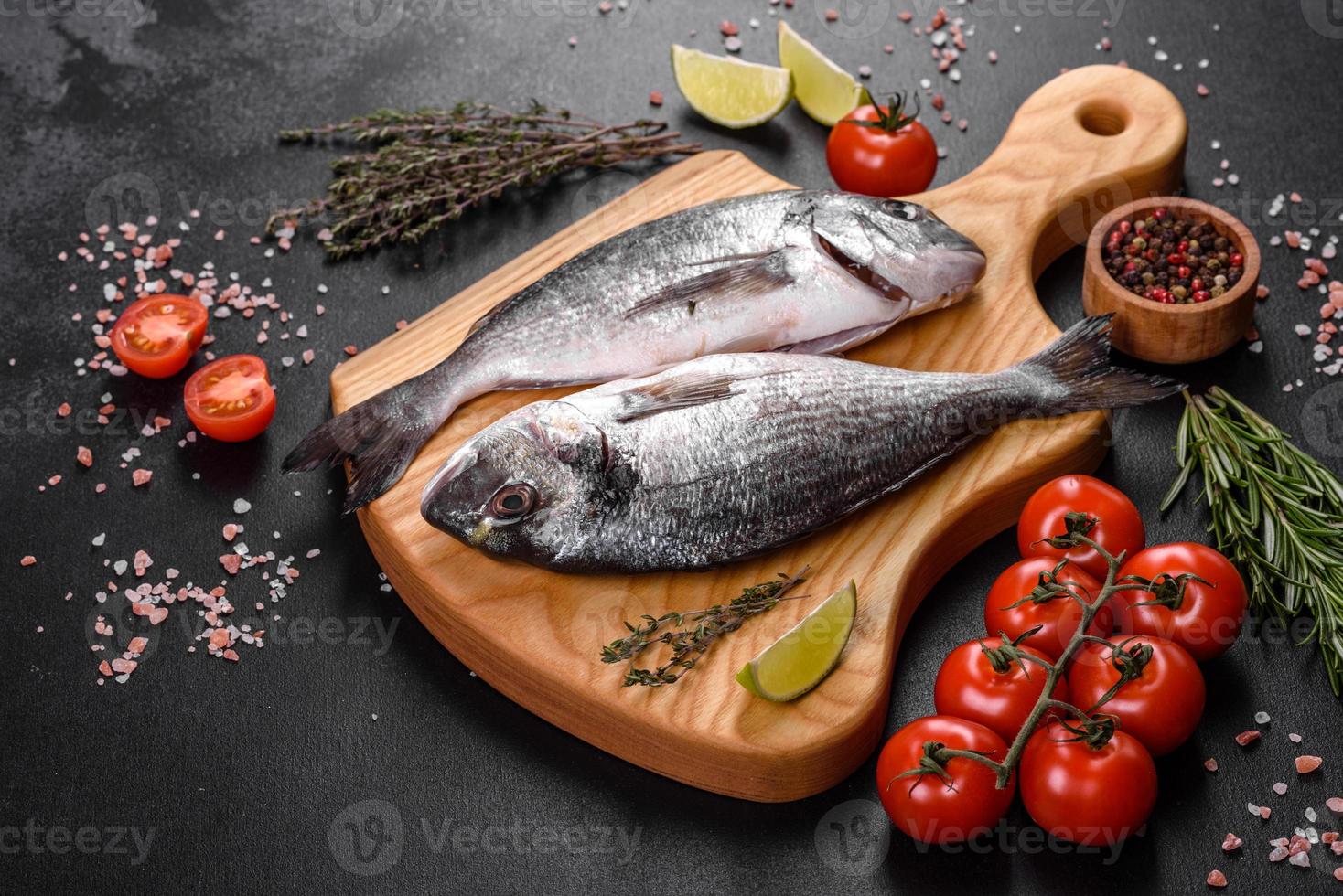 poisson dorado cru aux épices cuisant sur une planche à découper. daurade de poisson frais photo