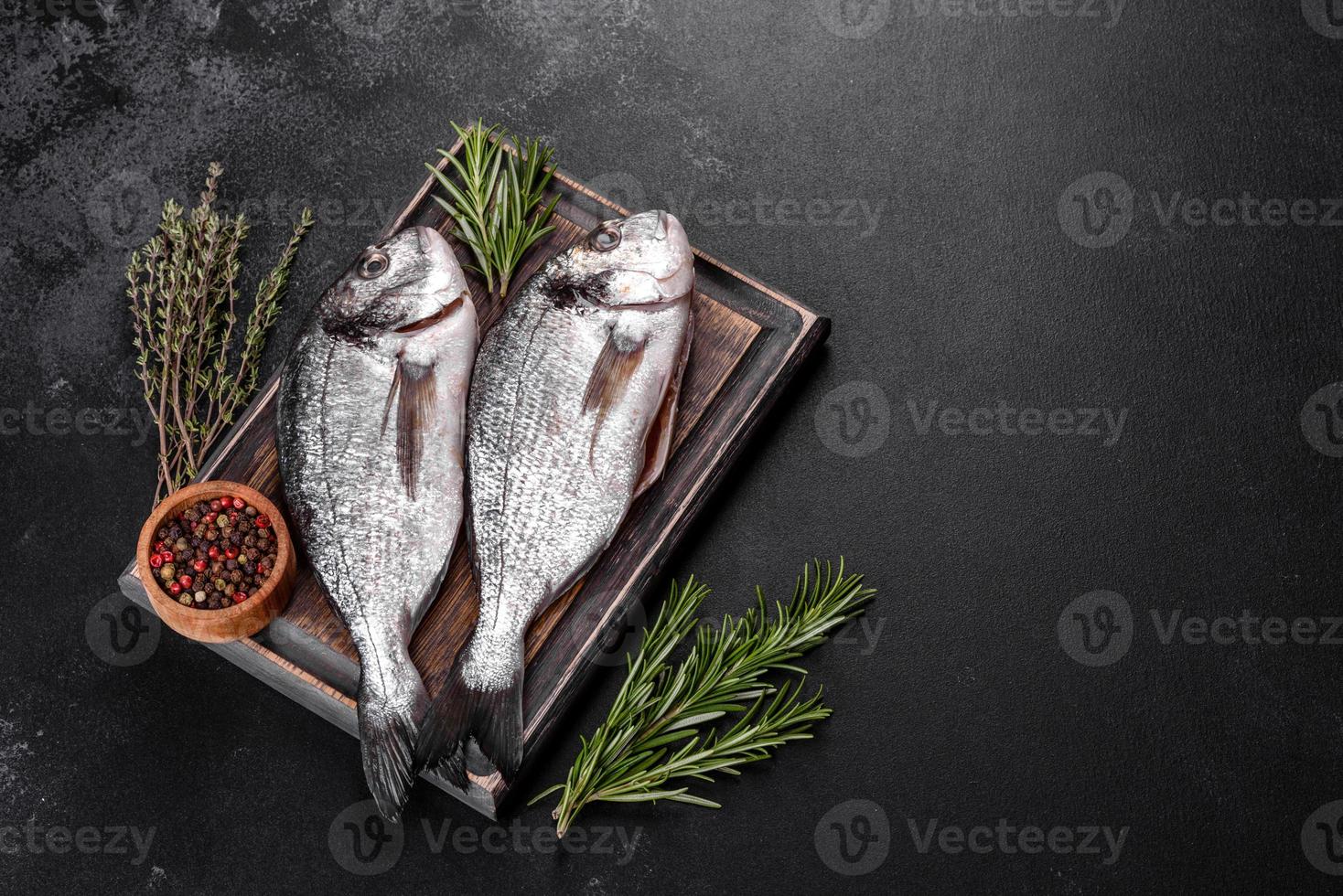 poisson dorado cru aux épices cuisant sur une planche à découper. daurade de poisson frais photo