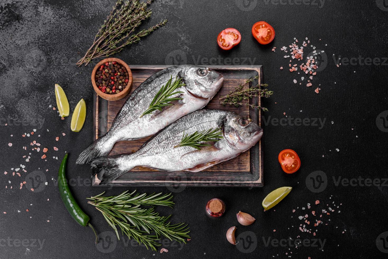 poisson dorado cru aux épices cuisant sur une planche à découper. daurade de poisson frais photo