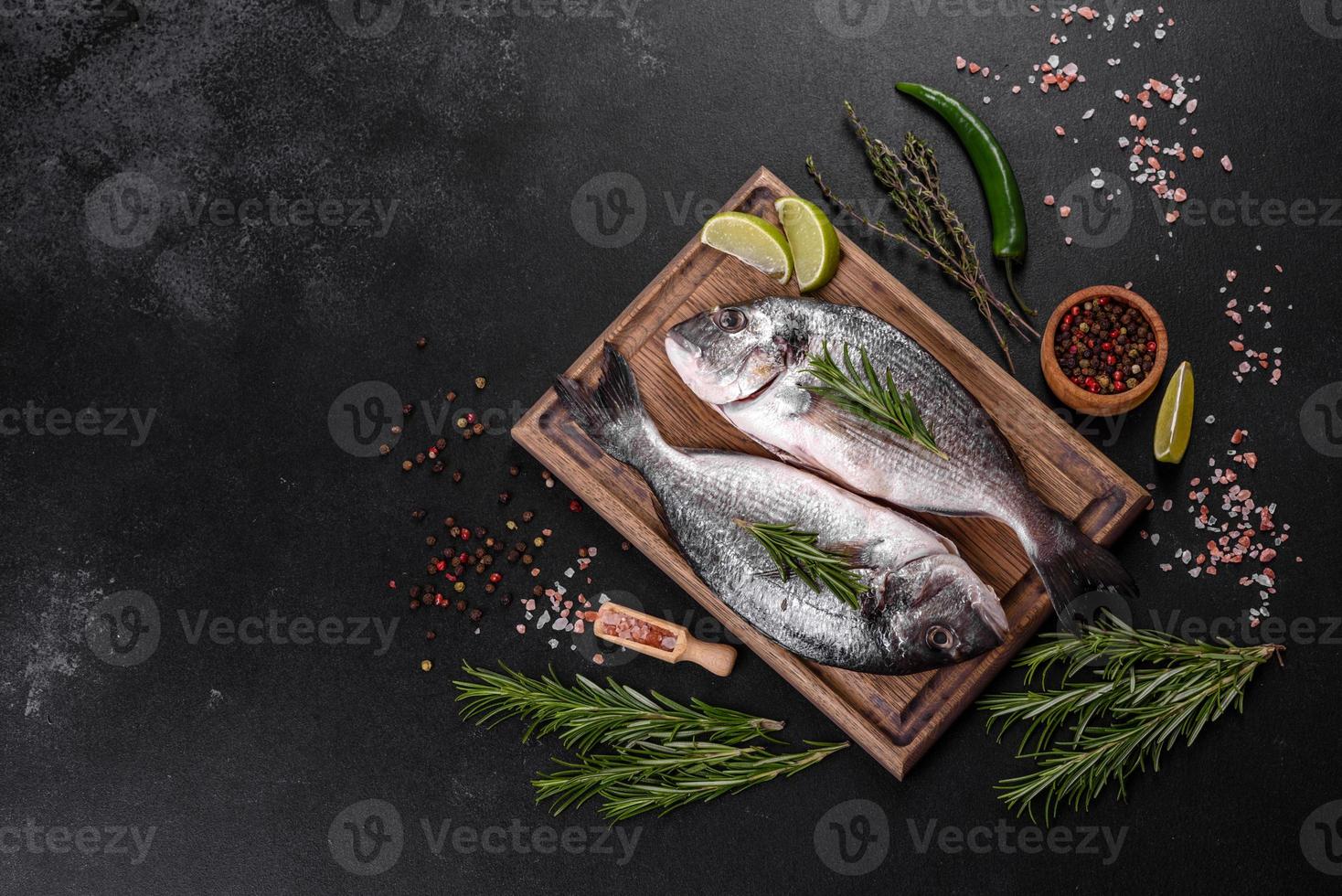 poisson dorado cru aux épices cuisant sur une planche à découper. daurade de poisson frais photo