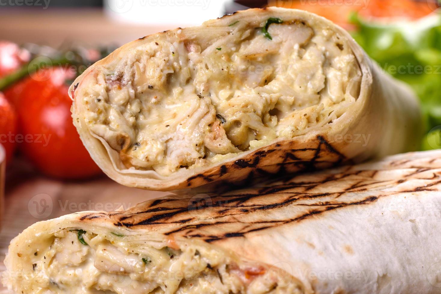 délicieux shawarma frais avec de la viande et des légumes sur une table en béton foncé photo