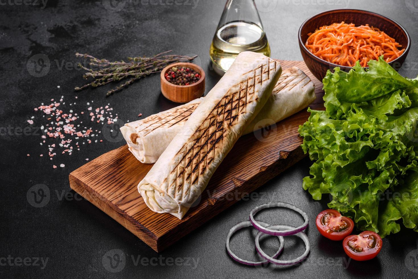 délicieux shawarma frais avec de la viande et des légumes sur une table en béton foncé photo