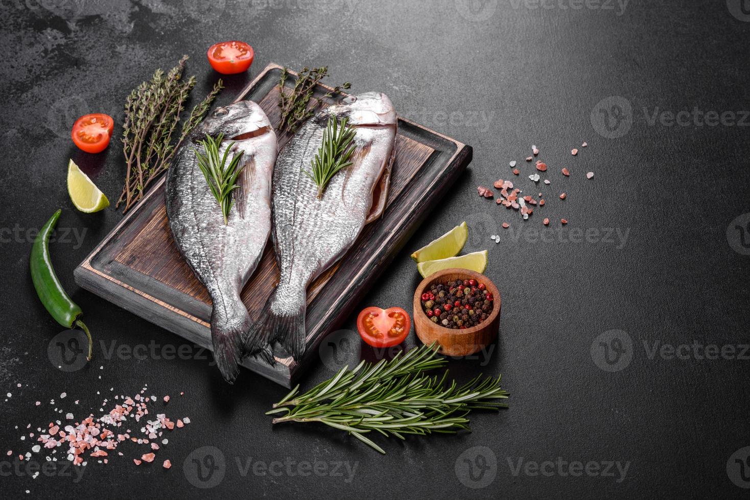 poisson dorado cru aux épices cuisant sur une planche à découper. daurade de poisson frais photo