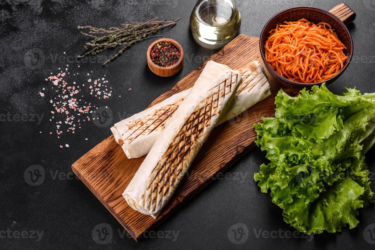délicieux shawarma frais avec de la viande et des légumes sur une table en béton foncé photo