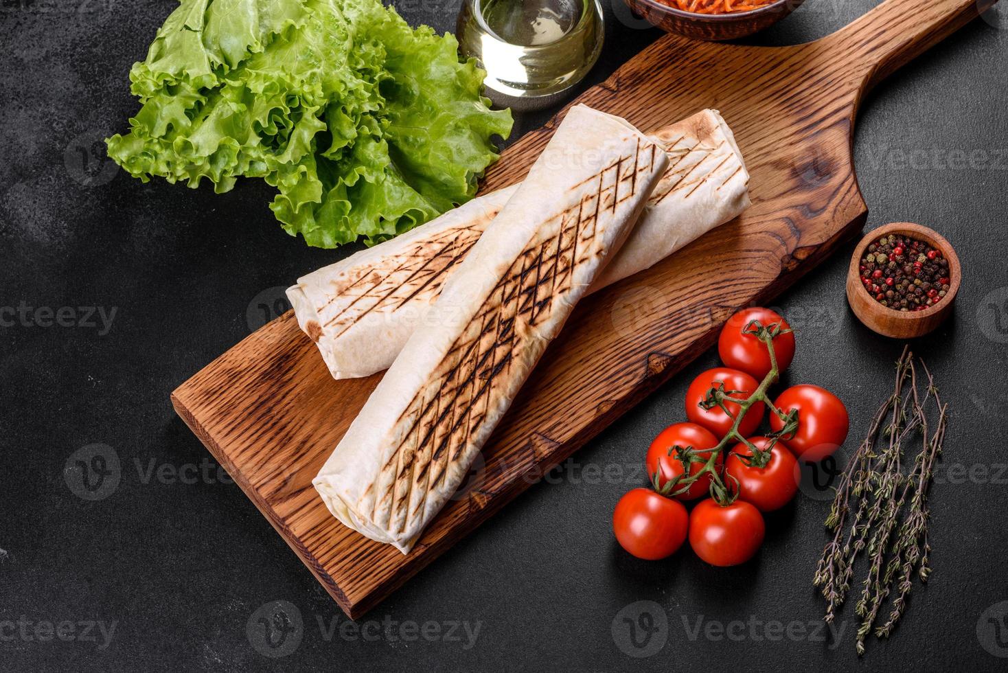 délicieux shawarma frais avec de la viande et des légumes sur une table en béton foncé photo