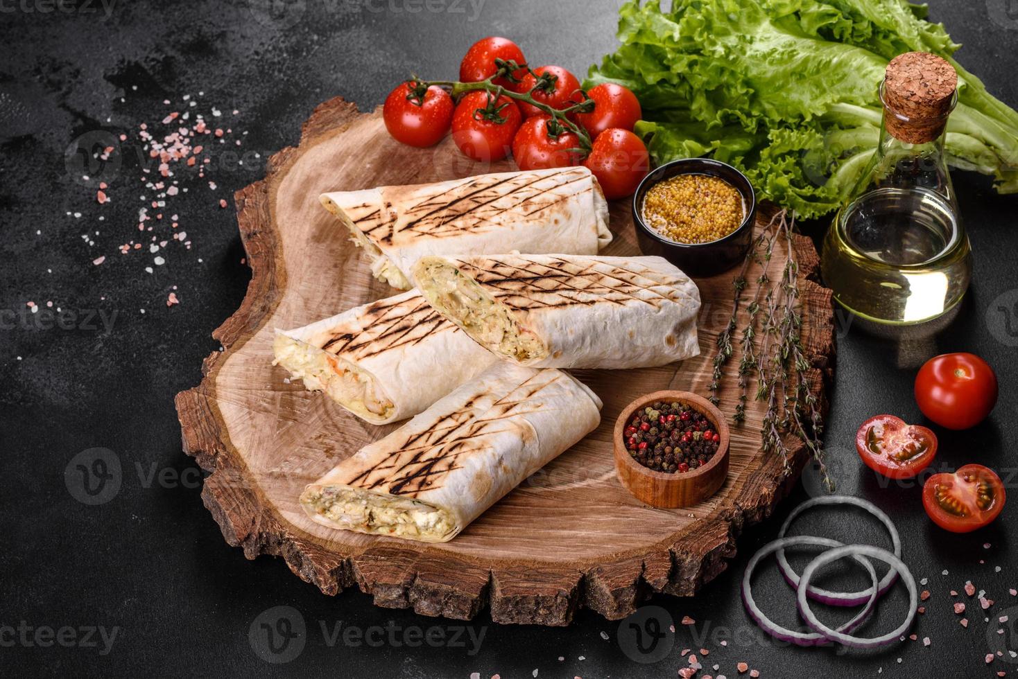 délicieux shawarma frais avec de la viande et des légumes sur une table en béton foncé photo