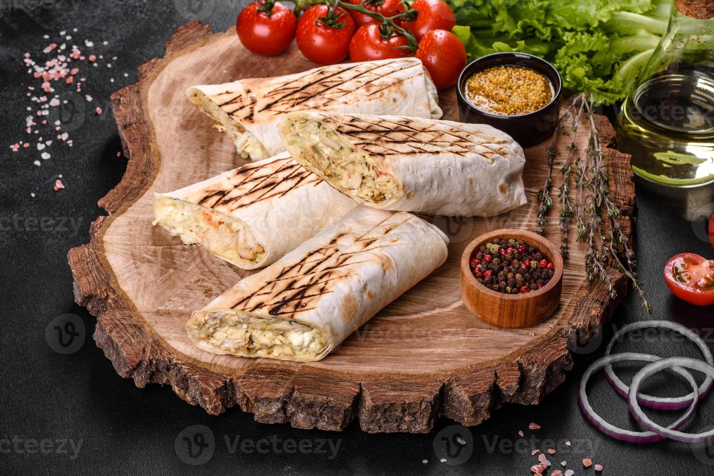 délicieux shawarma frais avec de la viande et des légumes sur une table en béton foncé photo