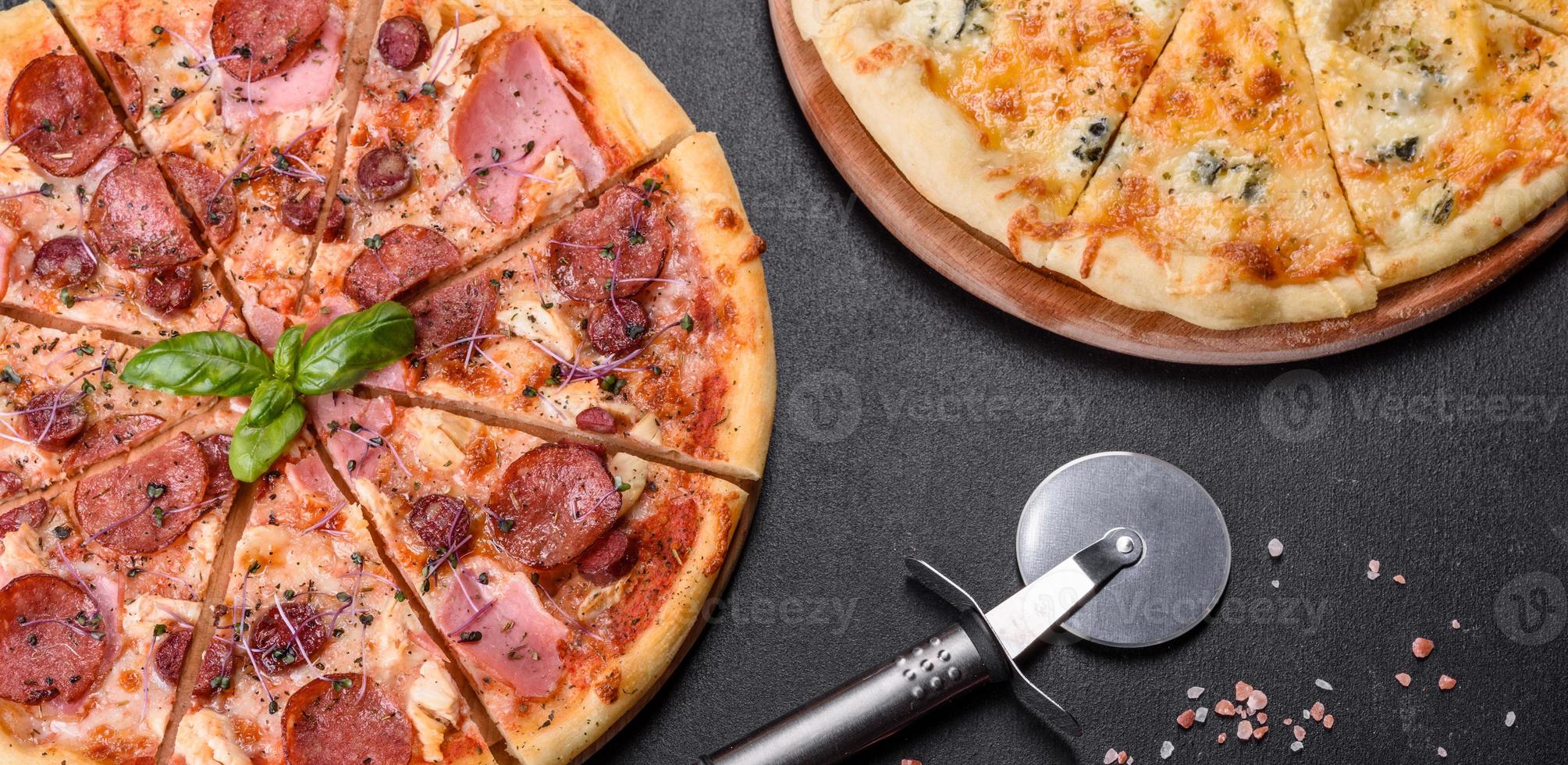 délicieuse pizza fraîche au four avec tomates, salami et bacon sur fond de béton foncé photo