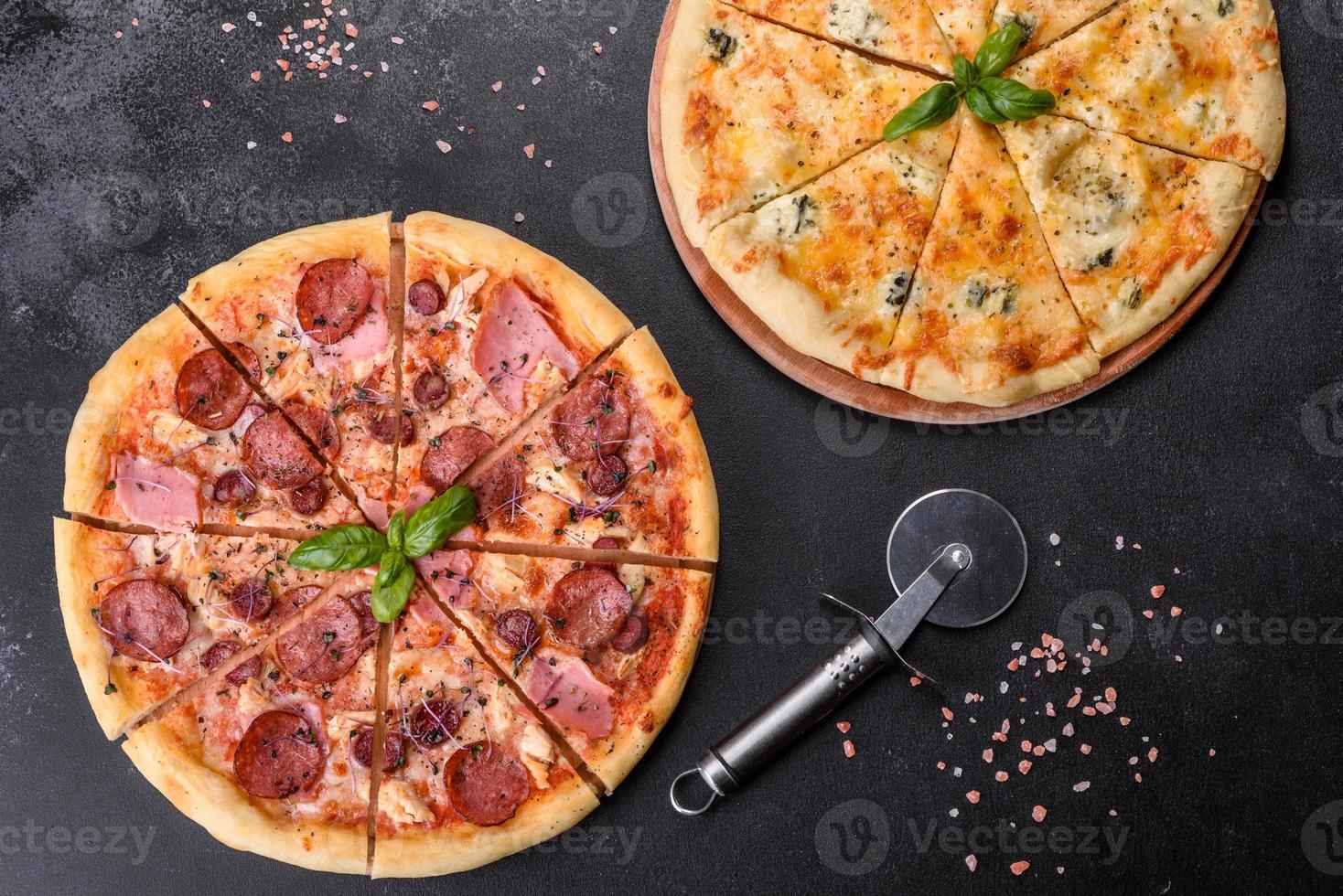 délicieuse pizza fraîche au four avec tomates, salami et bacon sur fond de béton foncé photo