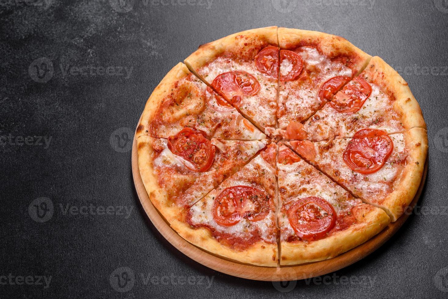 savoureuse pizza au four frais avec tomates, fromage et basilic sur fond de béton photo