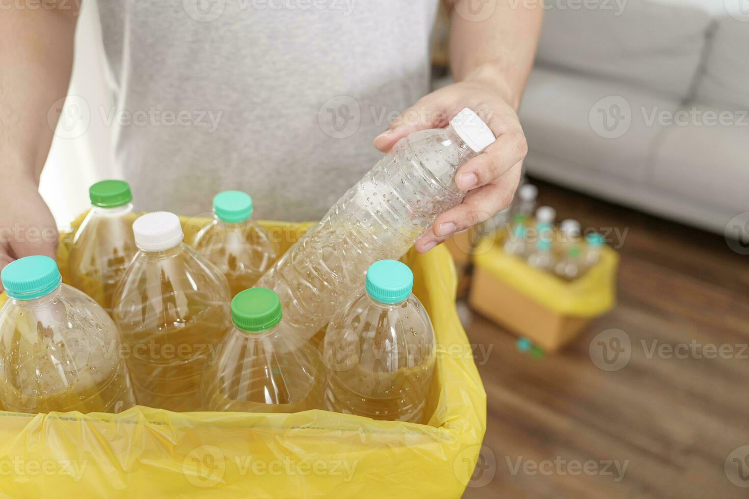 Accueil recycler éco vert zéro concept homme lancement vide Plastique bouteille dans recyclage poubelle avec Jaune des ordures Sacs à Accueil photo