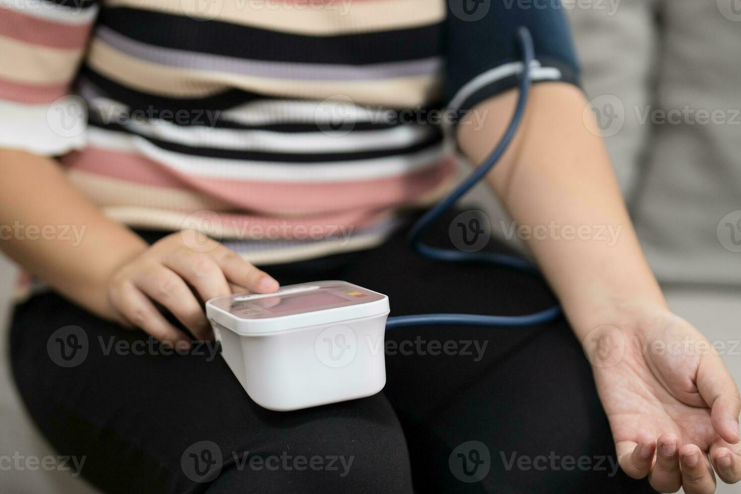 femme en surpoids plus Taille soi chèques mesure du sang pression et cœur taux tonomètre soi vérification à Accueil photo