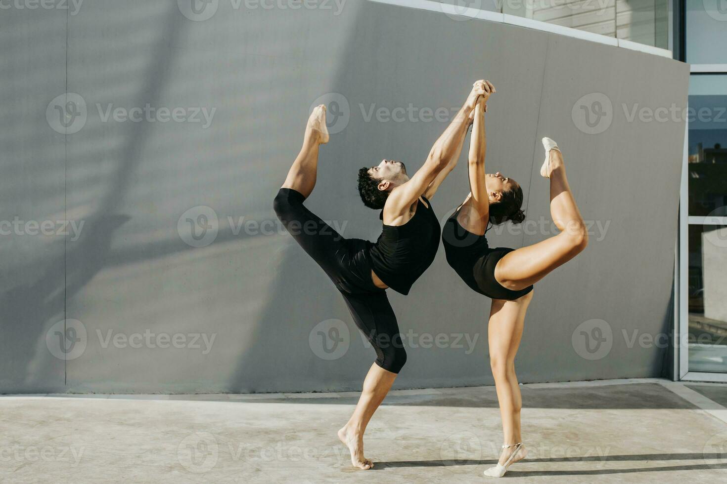 professionnel gymnastes permanent sur un jambe tandis que équilibrage par gris mur photo