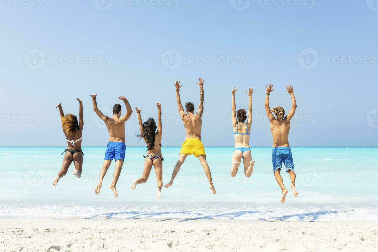 groupe de copains à le plage, sauter pour joie photo