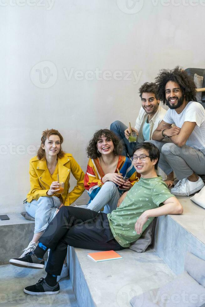 portrait de groupe de copains séance sur escaliers ayant une boisson photo