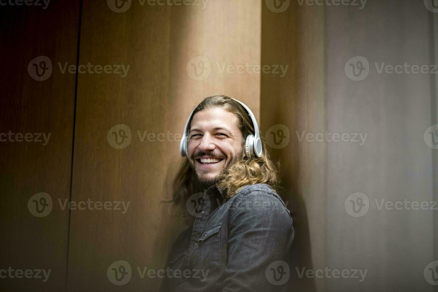 portrait de en riant homme écoute la musique avec écouteurs photo