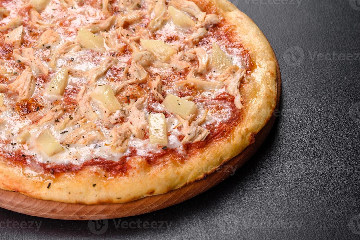 savoureuse pizza au four frais avec tomates, fromage et ananas sur fond de béton foncé photo
