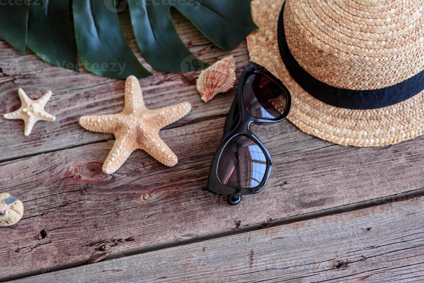 lunettes et chapeau avec coquillages et étoiles de mer sur fond coloré photo