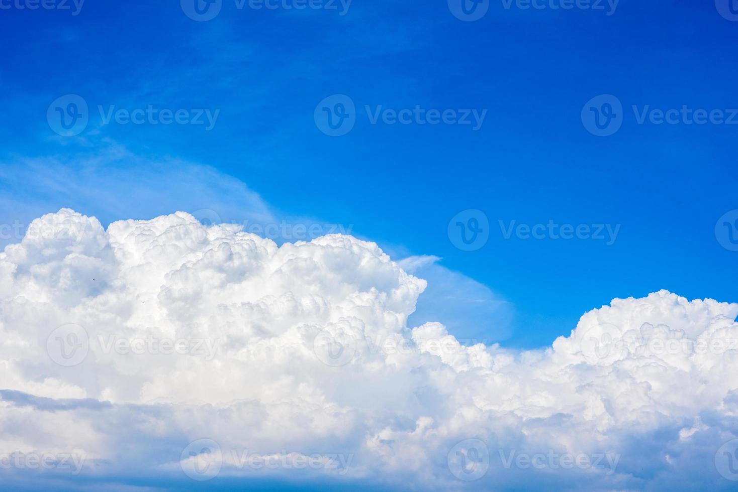 beaux nuages blancs dans un ciel bleu vif par une chaude journée d'été photo