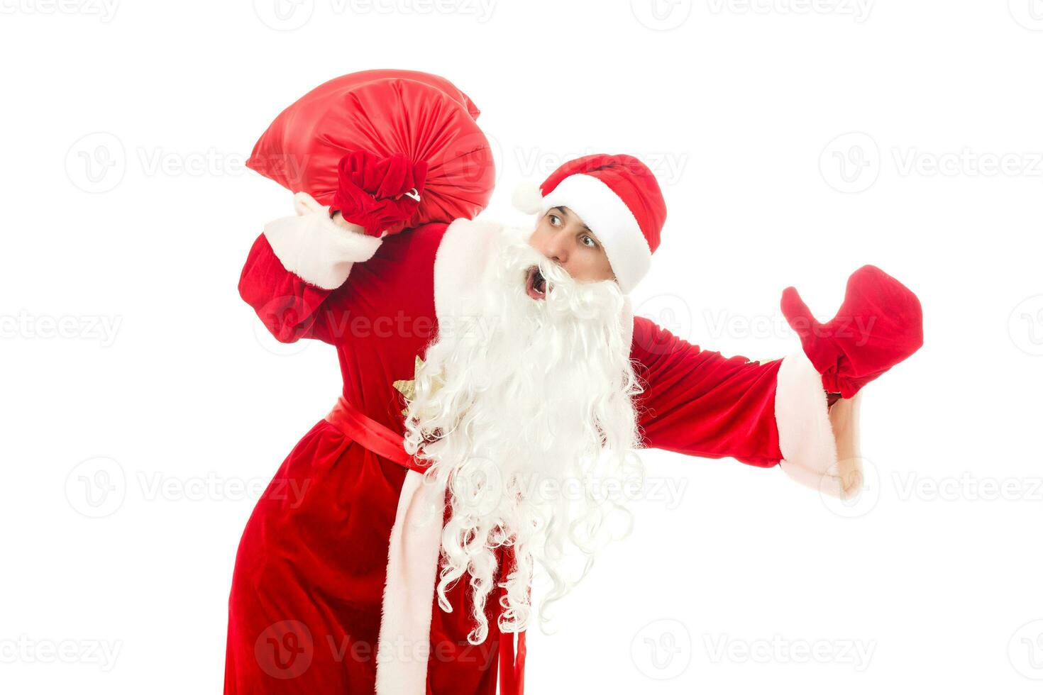 Père Noël claus permanent en haut sur blanc Contexte avec le sien sac plein de cadeaux photo