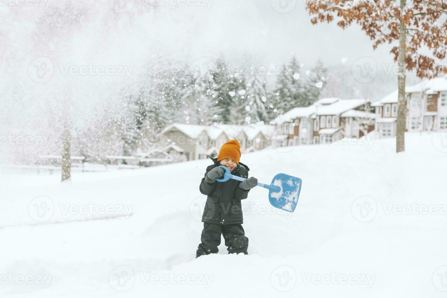 en riant peu garçon pelleter neige, Vancouver, Canada photo