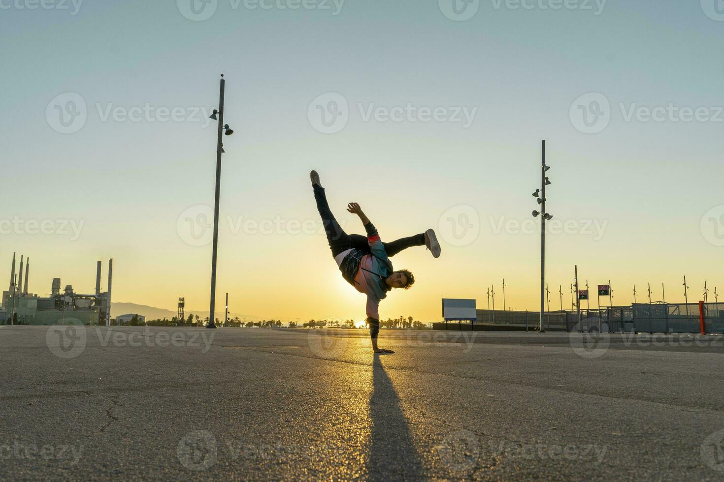 acrobate Faire appui renversé dans le ville à lever du soleil photo