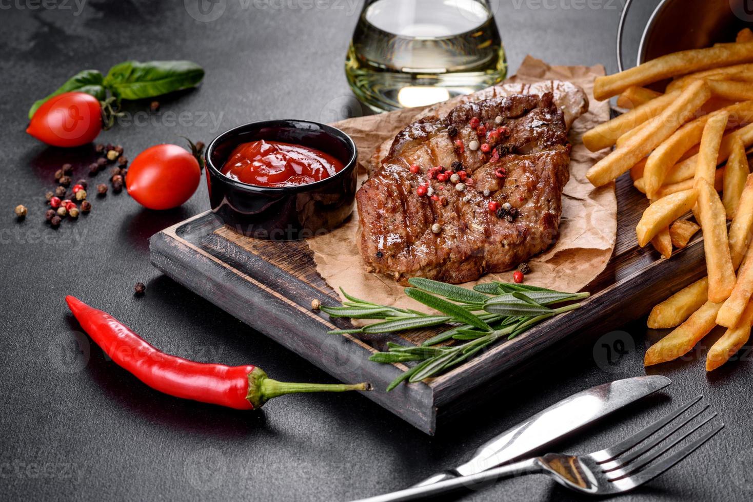 savoureux steak de bœuf cuit au four avec légumes, frites et épices photo