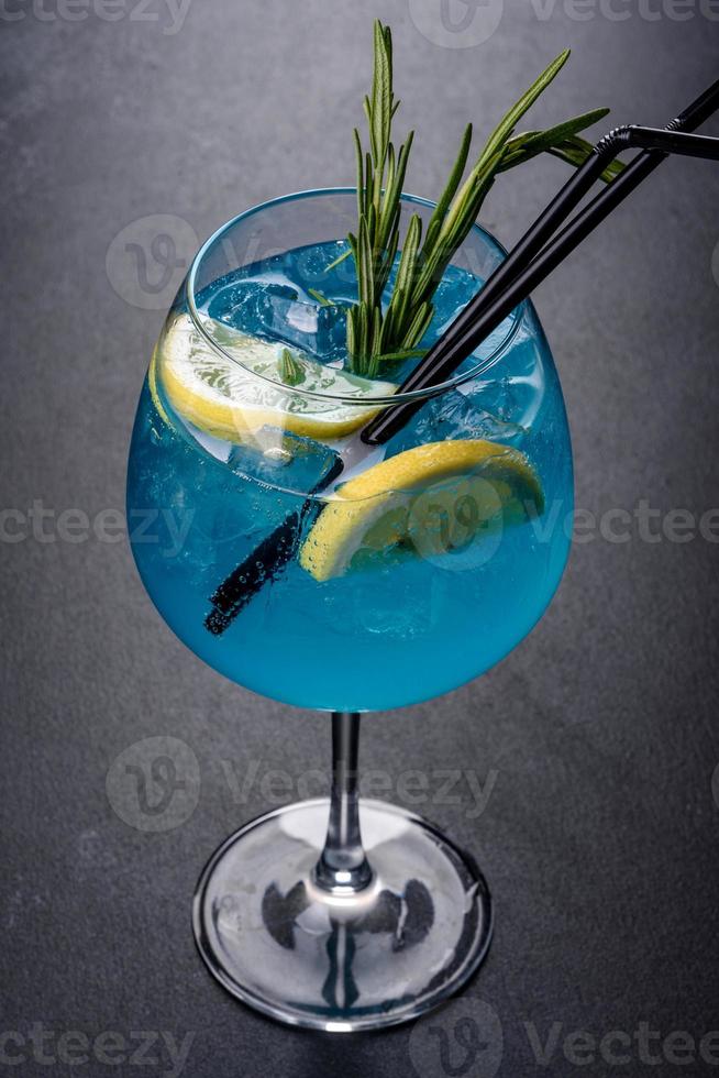 cocktail alcoolisé curaçao bleu avec glace, citron et tubes à cocktail photo