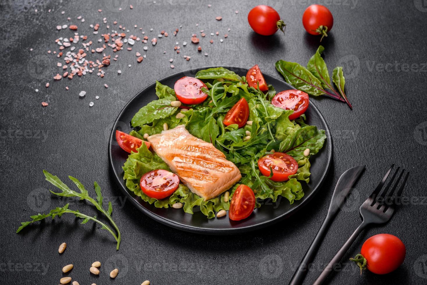 délicieuse salade fraîche avec du poisson, des tomates et des feuilles de laitue photo