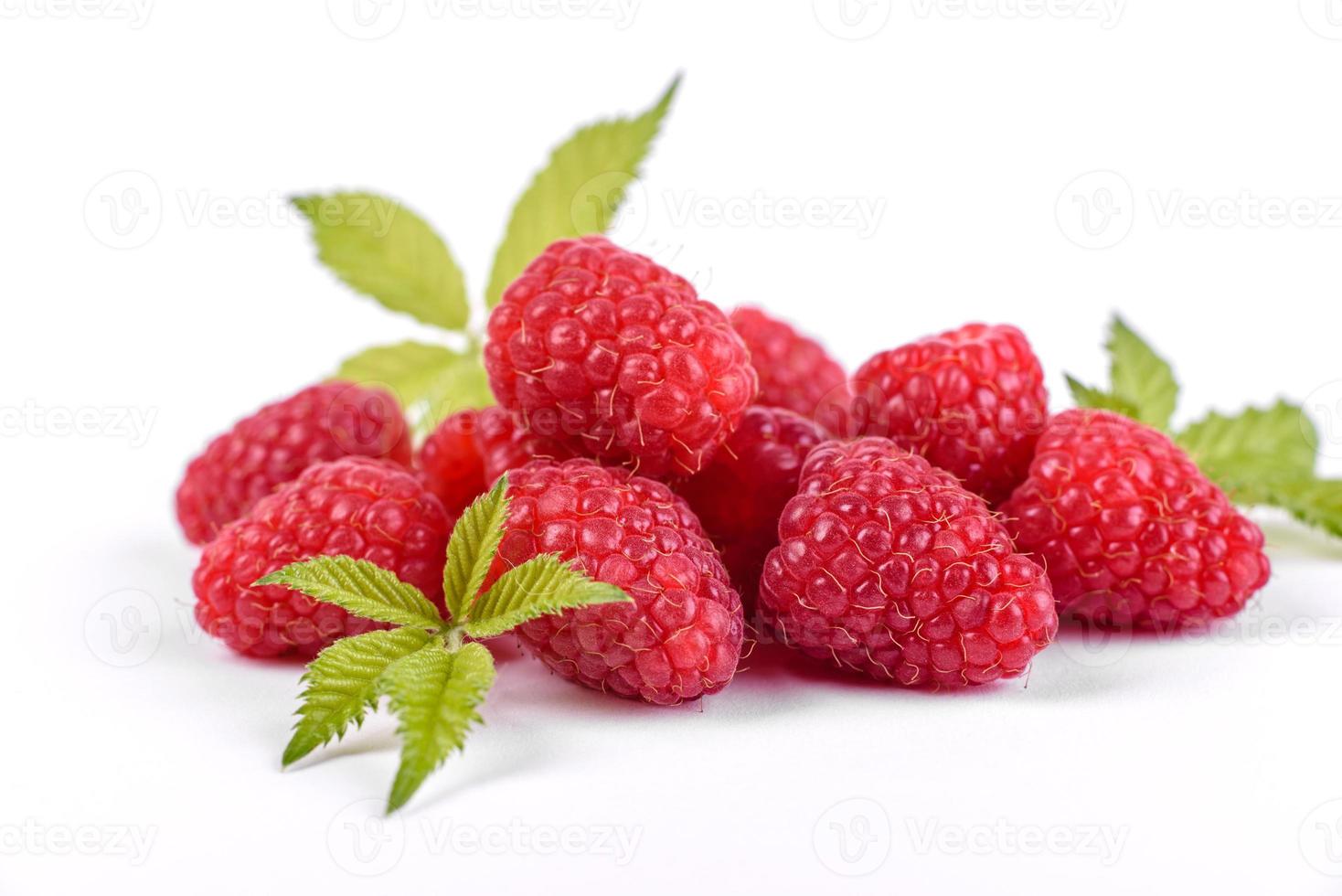 Framboises mûres avec feuille de framboise isolé sur fond blanc photo