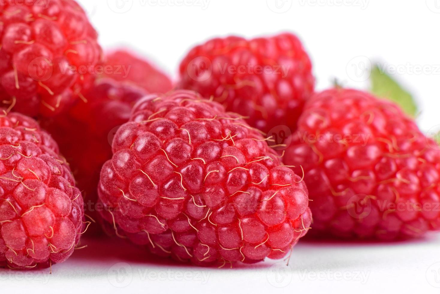 Framboises mûres avec feuille de framboise isolé sur fond blanc photo