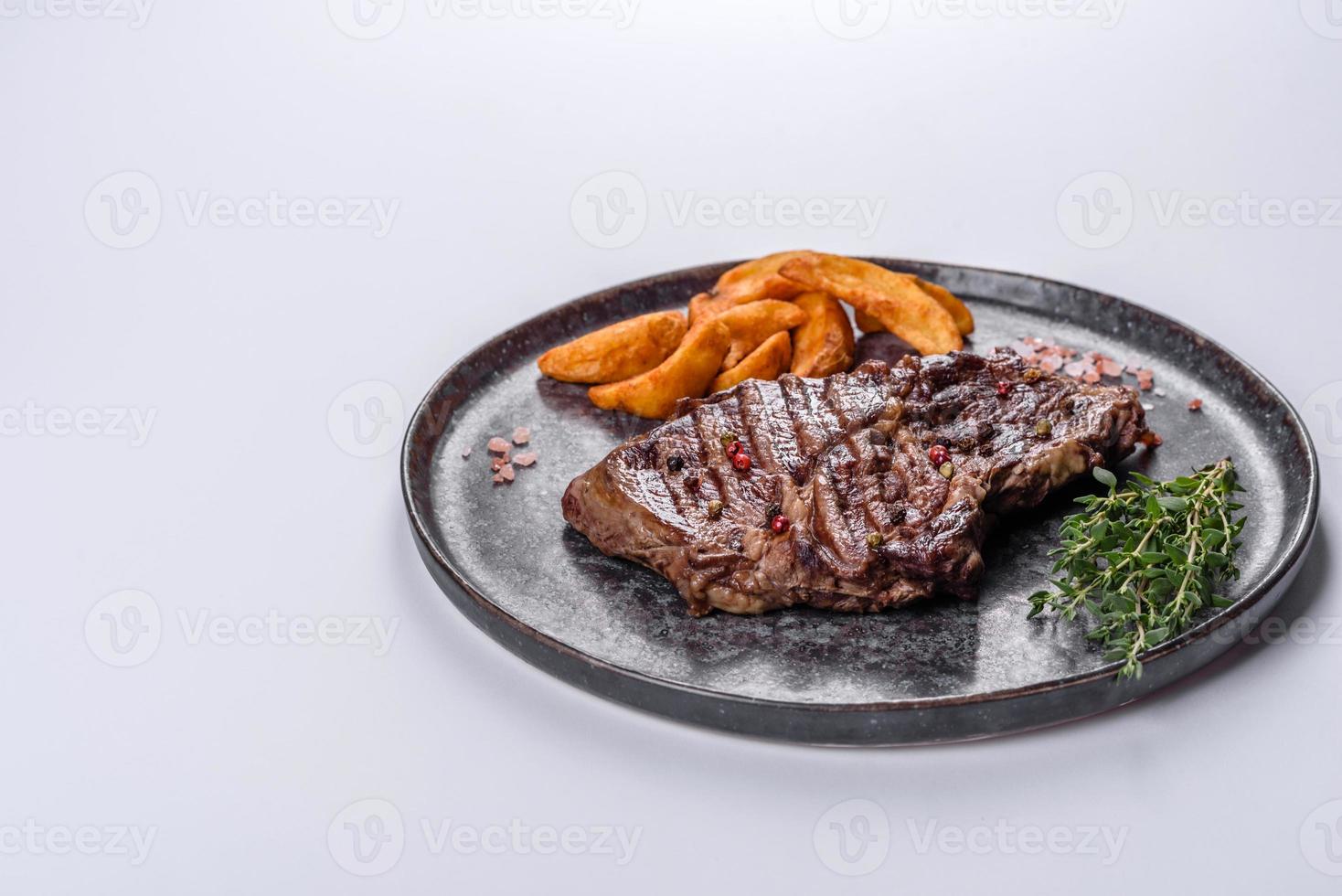 délicieux steak de boeuf frais juteux avec des épices et des herbes sur fond blanc photo