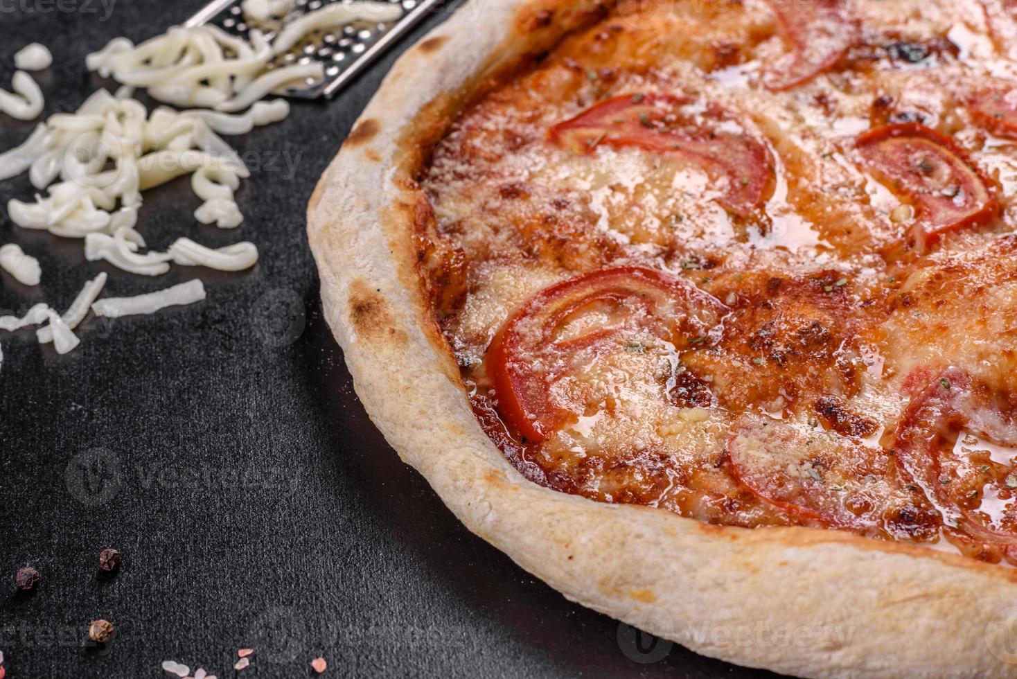 délicieuse pizza italienne fraîche aux champignons et tomates sur fond de béton foncé photo