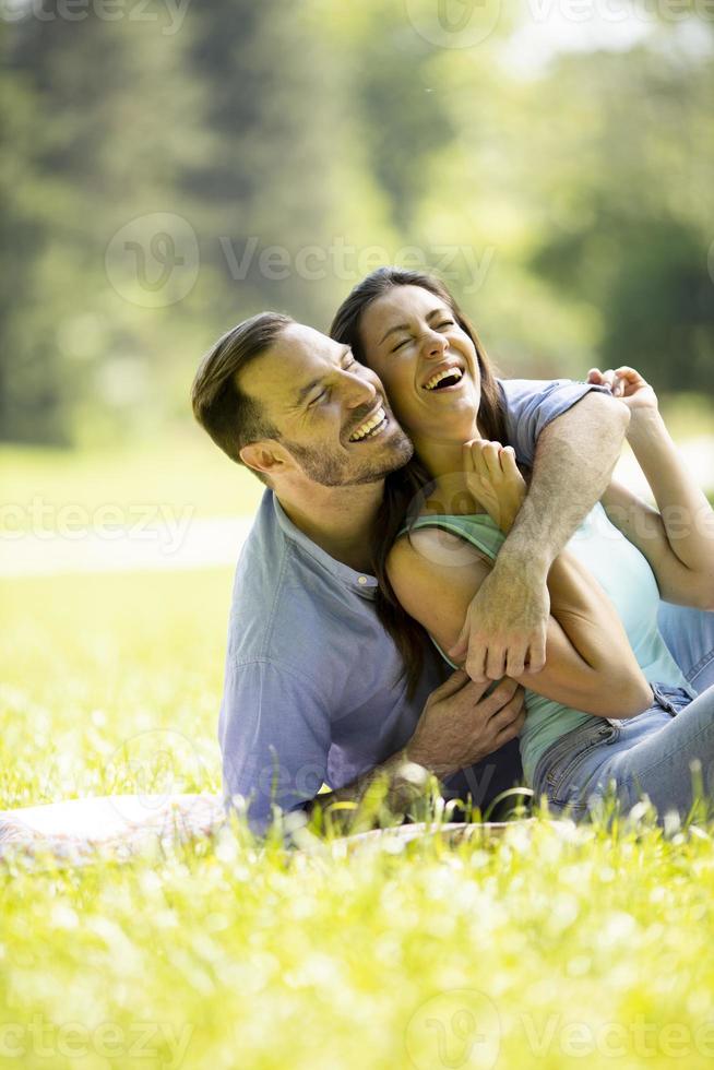 jeune couple affectueux assis sur l'herbe verte photo