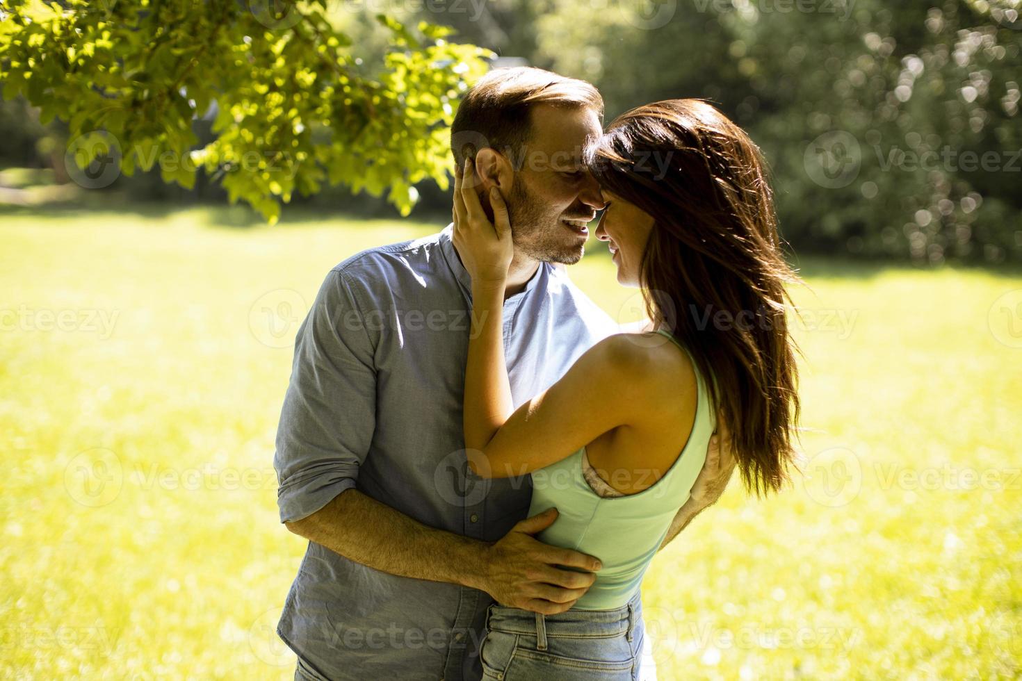 jeune couple affectueux s'amusant sur l'herbe verte photo