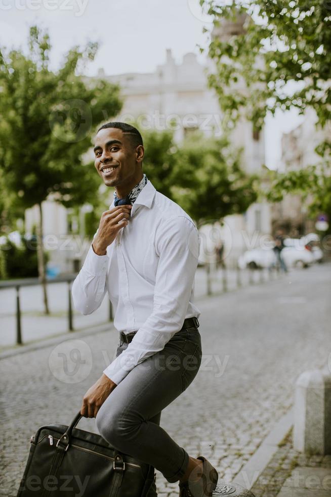 jeune homme d'affaires afro-américain en attente d'un taxi dans une rue photo