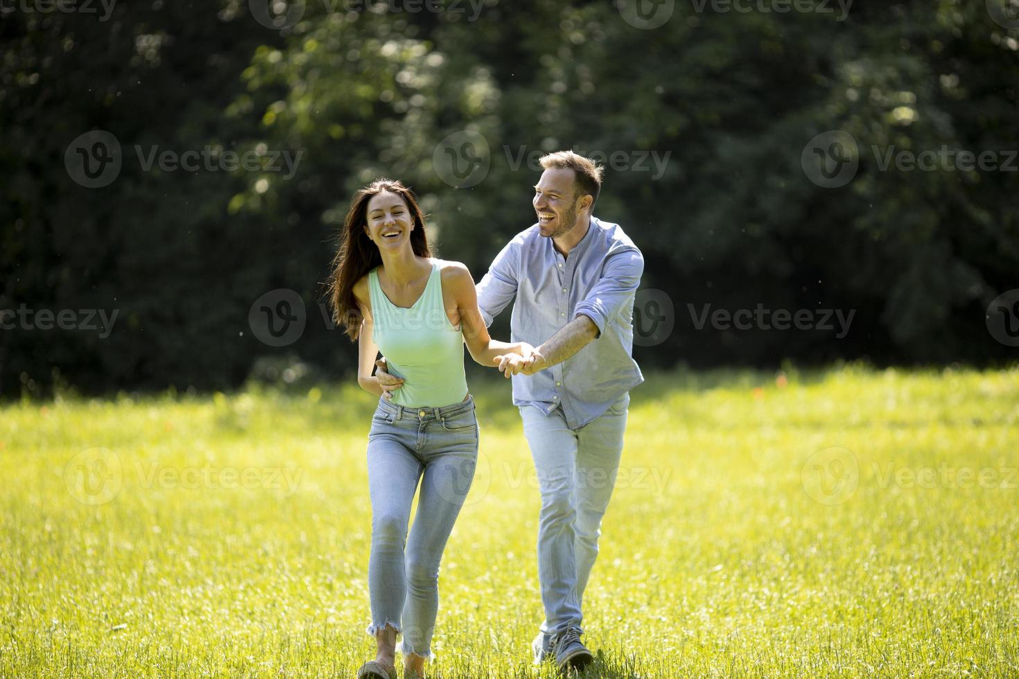 jeune couple affectueux s'amusant sur l'herbe verte photo