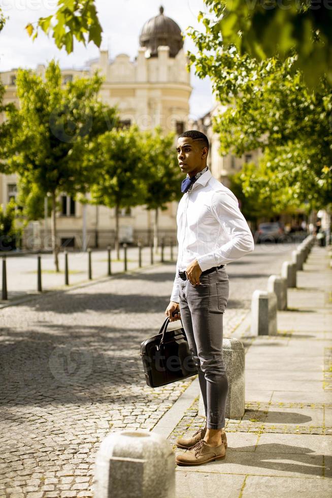 jeune homme d'affaires afro-américain en attente d'un taxi dans une rue photo