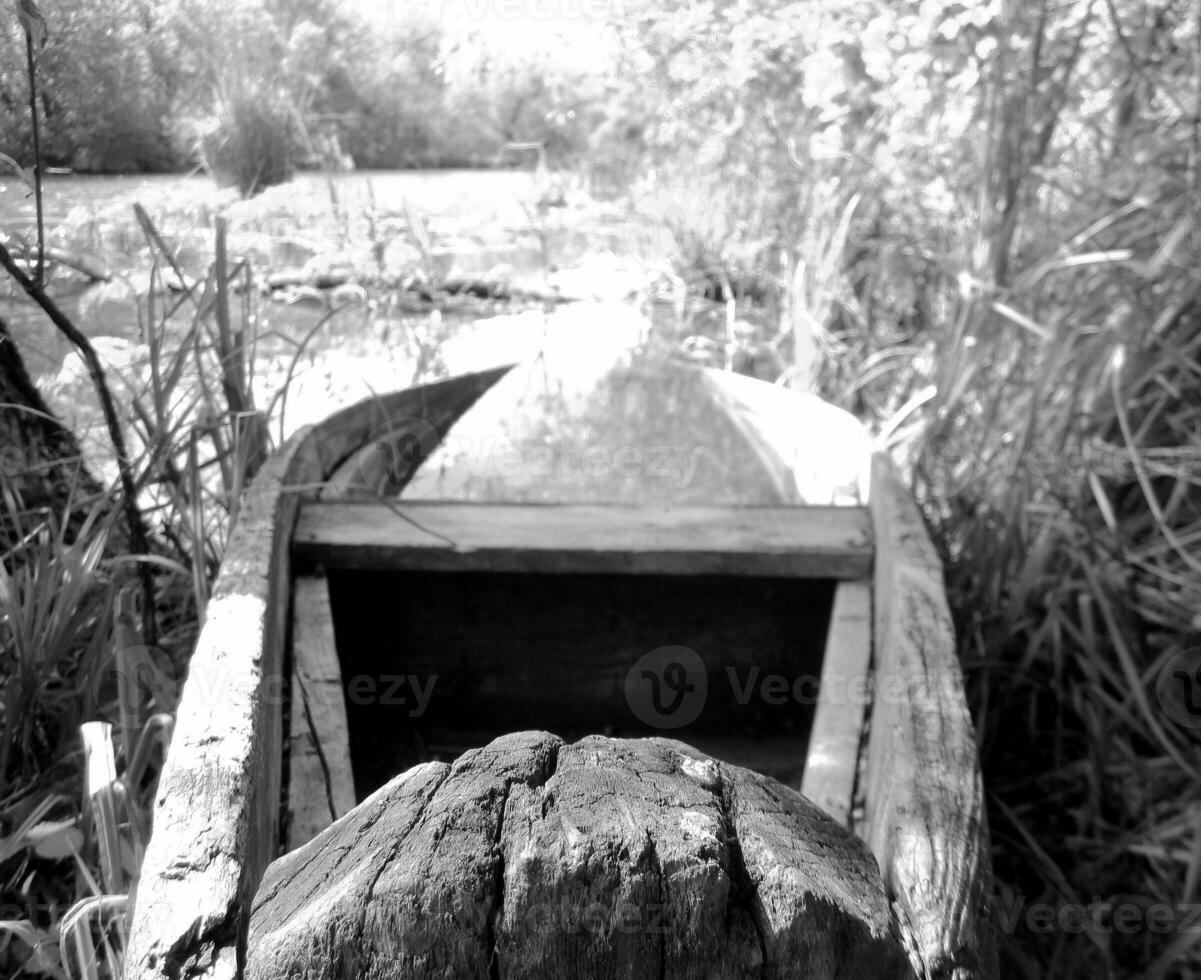 vieux bateau cassé en bois pour nager sur les rives de l'eau dans les roseaux naturels photo