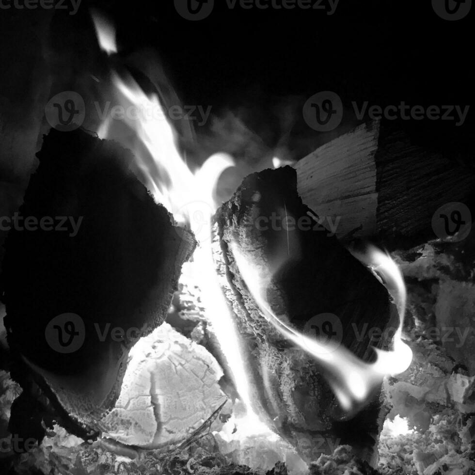 Belle flamme en bois brun charbon noir foncé sur feu jaune vif à l'intérieur d'un brasero en métal photo