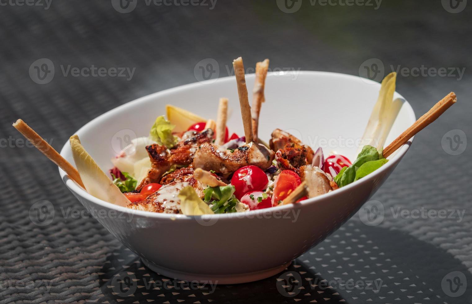 salade délicieuse et joliment préparée avec du poulet et des légumes. photo