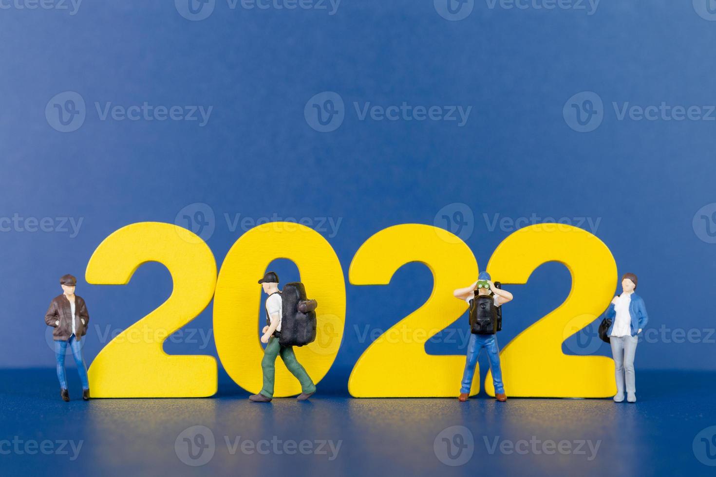 Backpacker de personnes miniatures debout sur le numéro en bois 2022 photo