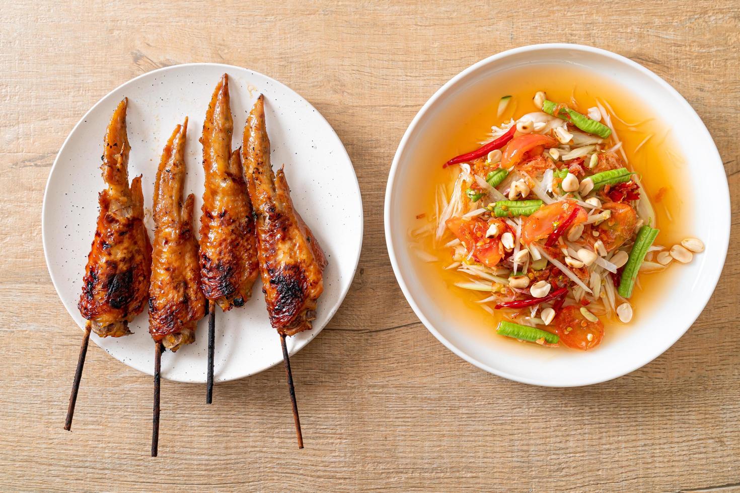 salade épicée de papaye avec du poulet grillé - style de cuisine de rue traditionnelle thaïlandaise photo