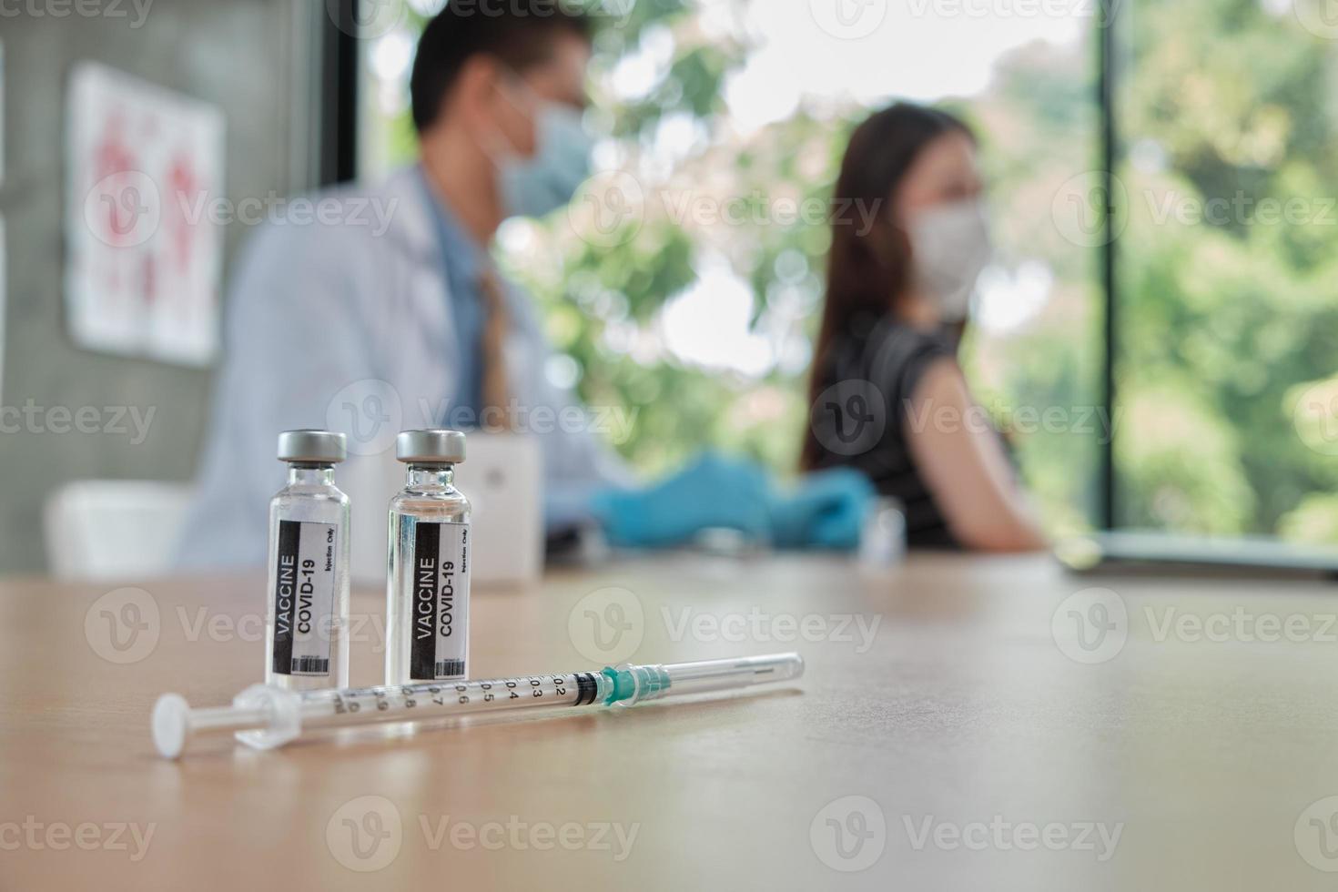 médecin de sexe masculin vaccinant une femme asiatique pour protéger covid19. photo